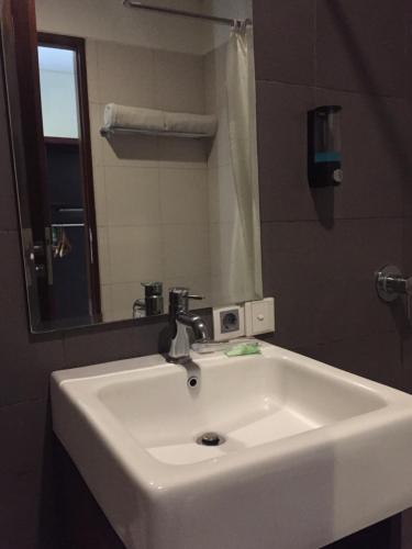 a white sink in a bathroom with a mirror at Suris Boutique Hotel in Kuta