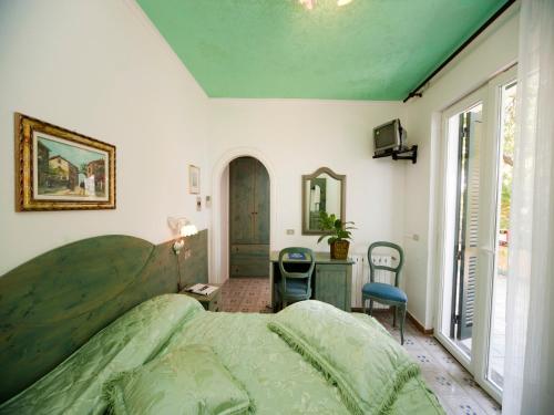 a bedroom with a large bed and a window at Hotel Giardino Delle Ninfe E La Fenice in Ischia