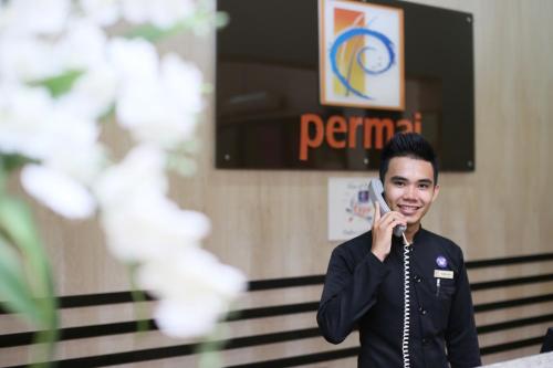 a young man talking on a cell phone at Permai Hotel Kuala Terengganu in Kuala Terengganu