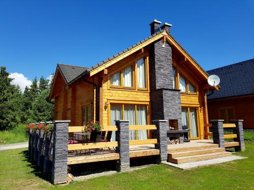 a log house with a porch and a fence at Chata Nikol in Tatranská Lomnica