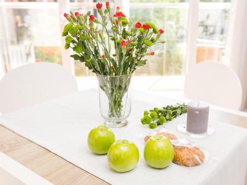 a vase of flowers and green apples on a table at NEPTUN 46 - 2 sypialnie in Olsztyn