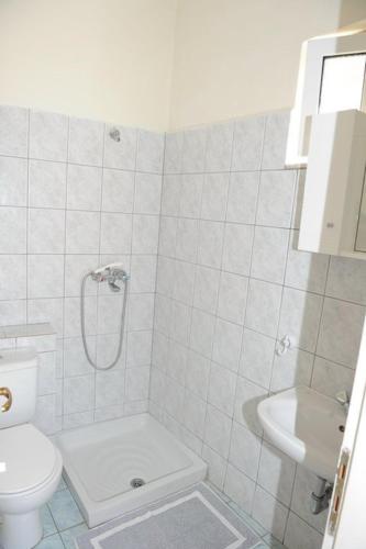 a white bathroom with a toilet and a sink at Mediterraneo studios in Vasiliki