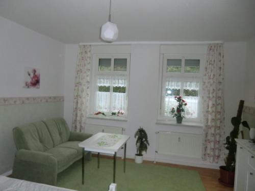 a living room with a couch and a table at Ferienwohnung Rosenflair in Schönebeck