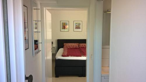 um quarto com uma cama com uma almofada vermelha em Studio Muenster City em Münster