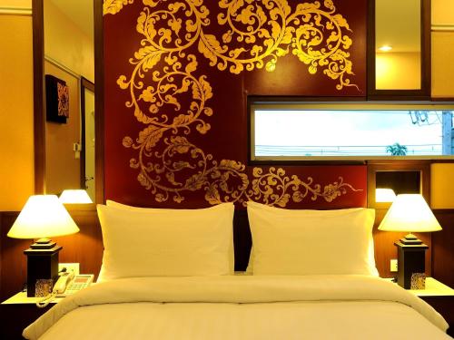 a bedroom with a large bed and two lamps at Mariya Boutique Hotel At Suvarnabhumi Airport in Lat Krabang