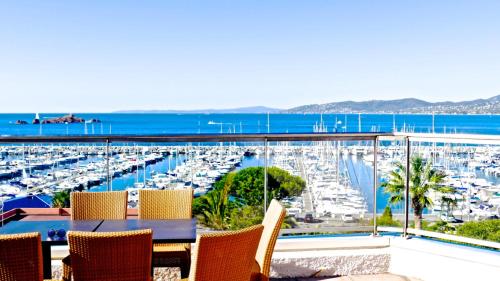 a balcony with a table and chairs and a marina at Hotel Brise de Mer - Piscine intérieure & extérieure in Saint-Raphaël