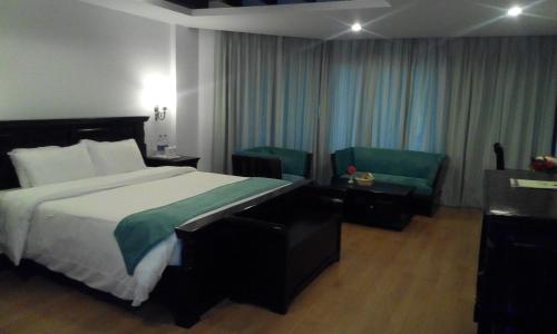 a hotel room with a bed and a chair at Manuallaya The Resort & Spa in Manāli