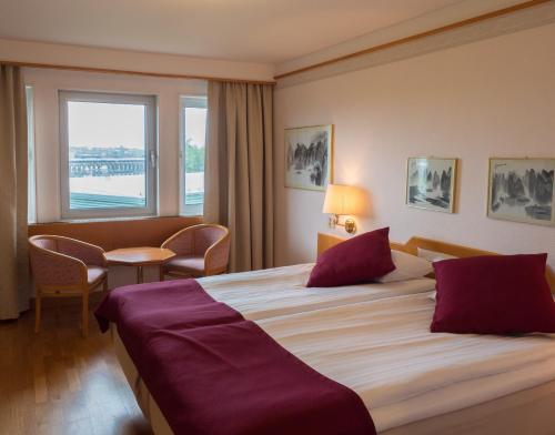 a hotel room with a large bed and a window at 2Home Stockholm South in Stockholm