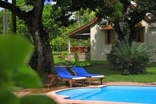 two blue chairs next to a swimming pool at Auberge de Saint Aubin in LʼUnion