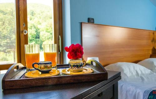 uma bandeja com duas bebidas e um vaso com uma flor em B&b Rosaria Amalfi Coast em Vietri