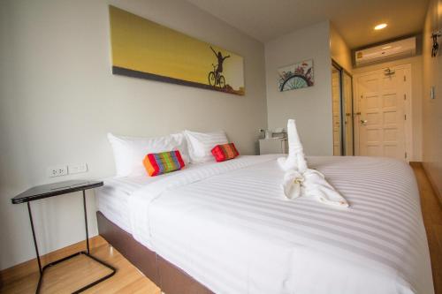 a bedroom with a large white bed in a room at Ducati Bike Box Hotel in Buriram