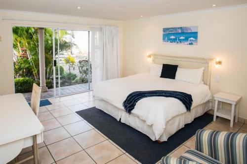 1 dormitorio con cama y ventana grande en Santorini Guesthouse en East London