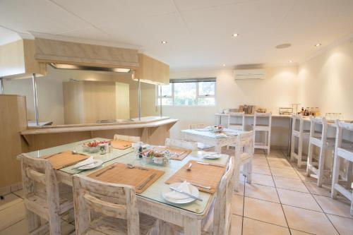 a kitchen with a table and chairs in a room at Santorini Guesthouse in East London