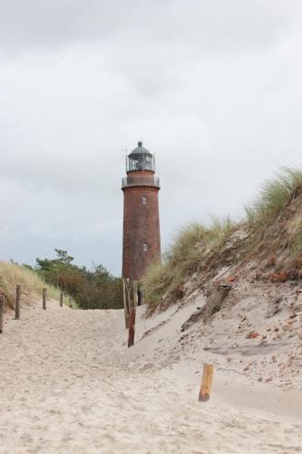 a lighthouse sitting on top of a sandy beach at Best Western Plus Ostseehotel Waldschloesschen in Prerow