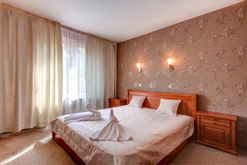 a bedroom with a bed with a dress on it at Family Hotel Prestige in Burgas