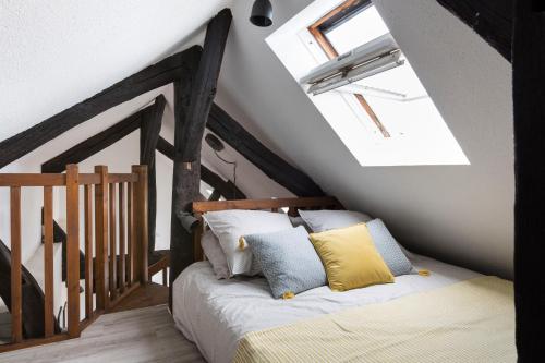 une chambre avec un lit et une lucarne dans l'établissement Les Lices by Cocoonr, à Rennes