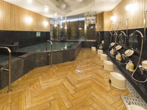 baño grande con piscina y aseos en Hotel Minatoya, en Kochi