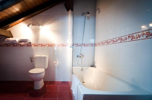 y baño con aseo y bañera. en Hotel Villa Miramar en Poo de Llanes