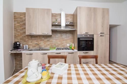 a kitchen with a table with a checkered table cloth at Rifugio Massafera 2 in Massafra
