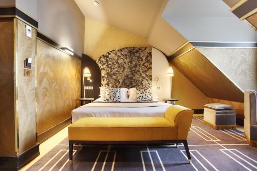 Habitación de hotel con cama y banco amarillo en Maison Nabis by HappyCulture, en París