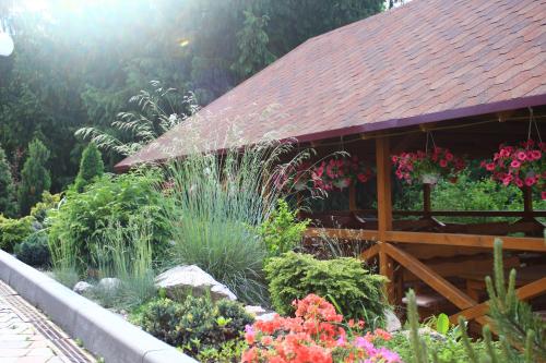a garden in front of a building with flowers at Grand Hotel Pylypets in Pilipets
