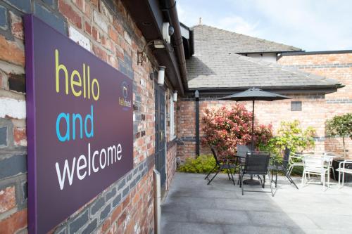 un cartello sul lato di un edificio con tavoli e sedie di Hello Hotel a Manchester