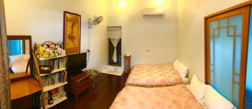 een slaapkamer met een bed en een boekenplank bij May的家民宿 in Suao