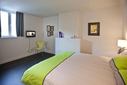 Un dormitorio con una cama con una manta verde. en Drabstraat 2 Apartment, en Gante