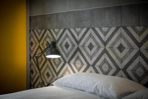 a bedroom with a bed and a wall with a headboard at Hotel San Daniele in San Daniele del Friuli
