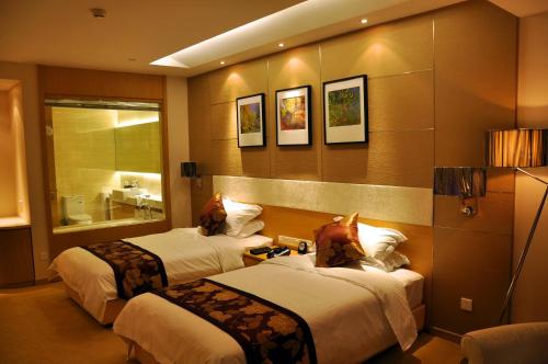 a hotel room with two beds and a bathroom at Suzhou Sun Plaza Hotel in Suzhou