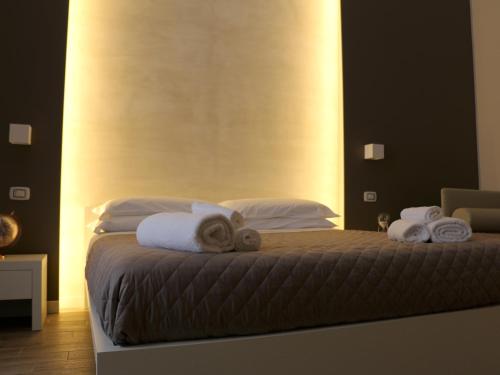 a bedroom with a bed with towels on it at La Banchina Holiday Rooms in Trani