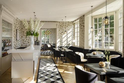 a restaurant with tables and chairs and windows at Boutique Hotel Des XV in Strasbourg