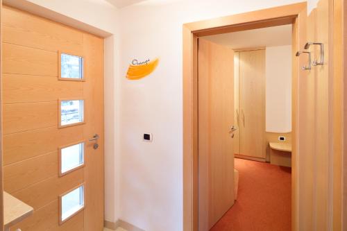 a bathroom with a door and a banana on the wall at Haus Angelika in Nova Levante