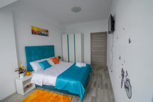 ママイアにあるRelax Apartmentのベッドルーム1室(青いヘッドボード付きのベッド1台付)