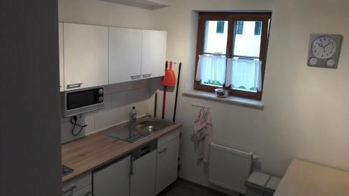 eine kleine Küche mit einem Waschbecken und einem Fenster in der Unterkunft Gästehaus Am Hothertor in Görlitz