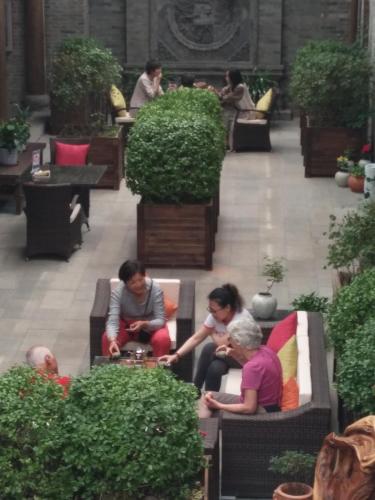 a group of people sitting on couches in a building at Water Hotel, Pingyao in Pingyao