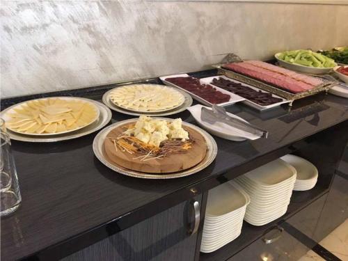 a buffet with plates of food on a table at Imperial Palace Hotel Yerevan in Yerevan
