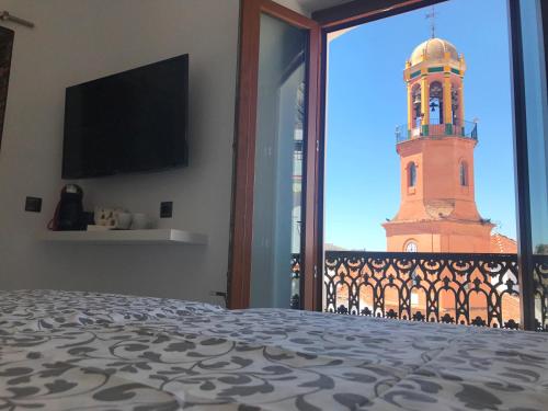 a bedroom with a view of a clock tower at Salamandra Plaza in Cómpeta
