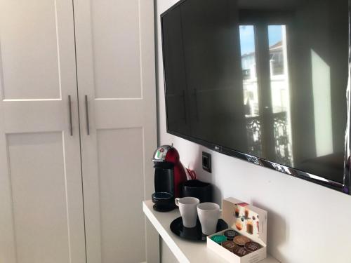a flat screen tv hanging on a wall next to a cabinet at Salamandra Plaza in Cómpeta