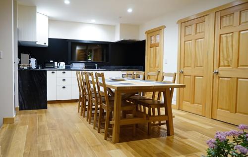 a kitchen with a wooden table and chairs at Harmony House Hakuba in Hakuba