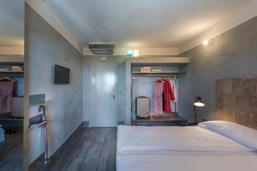 a bedroom with a white bed and a dressing room at Hotel San Daniele in San Daniele del Friuli