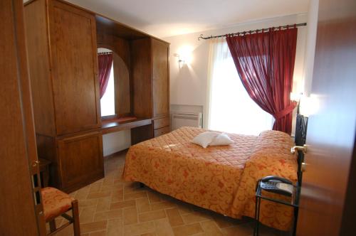 a bedroom with a bed and a window at Colleverde Country House & SPA Urbino in Urbino