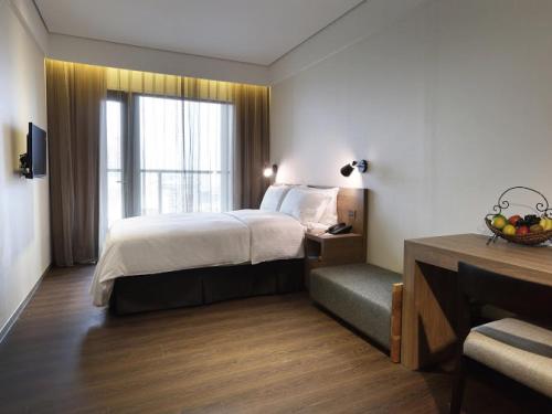 a hotel room with a bed and a window at Just Sleep Hualien ZhongZheng in Hualien City