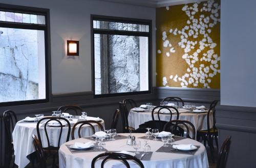 une salle à manger avec quatre tables et des nappes blanches dans l'établissement The Originals City, Hôtel Astoria Vatican, Lourdes (Inter-Hotel), à Lourdes