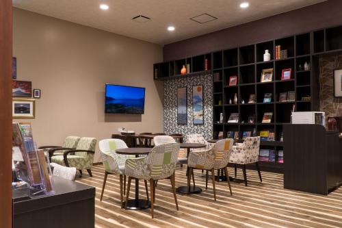 a library with chairs and a table and bookshelves at Mt.Fuji Cabin & Lounge Highland Station Inn (Capsule Hotel) in Fujikawaguchiko