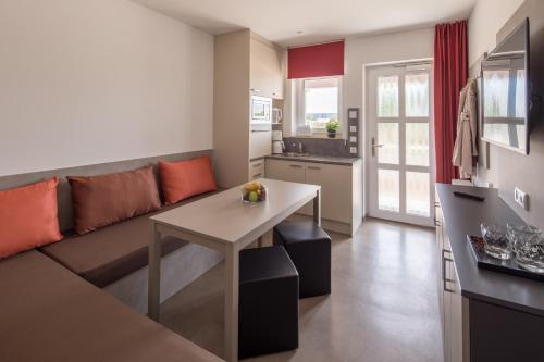 a living room with a couch and a table at TRIO Apartment Hotel Berlin in Berlin