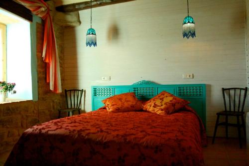 ein Schlafzimmer mit einem blauen Bett mit zwei Kissen in der Unterkunft Les Cavallerisses registre generalitat PT-00279 in Guialmons