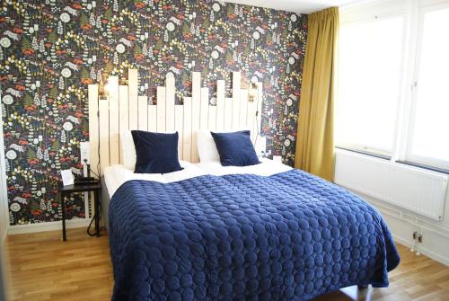 a bedroom with a large bed with a blue comforter at Hotel Falun in Falun