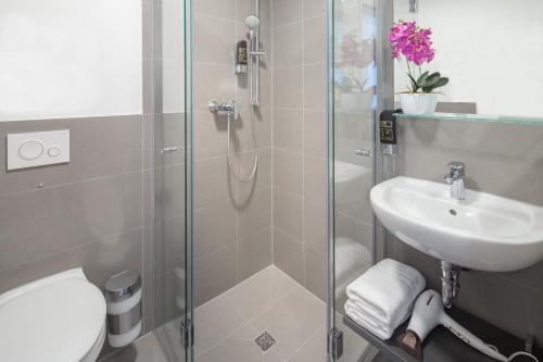 a bathroom with a shower and a sink and a toilet at TRIO Apartment Hotel Berlin in Berlin