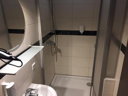 a bathroom with a shower and a sink at Hotel Ristorante Rostica in Bad Urach